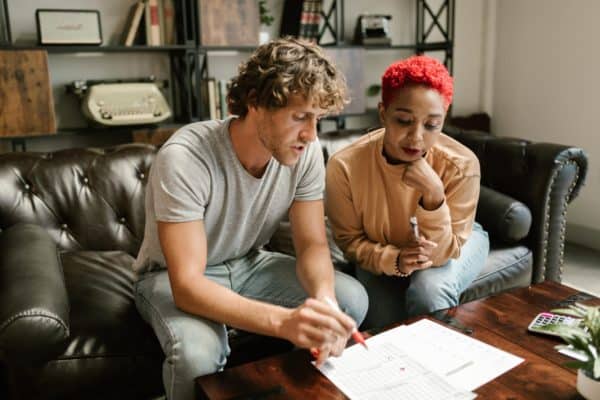 White man and black woman look closely at financial documents