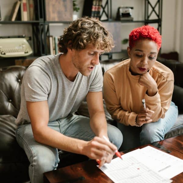 White man and black woman look closely at financial documents